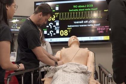 physician assistant students practice on a medical manikin