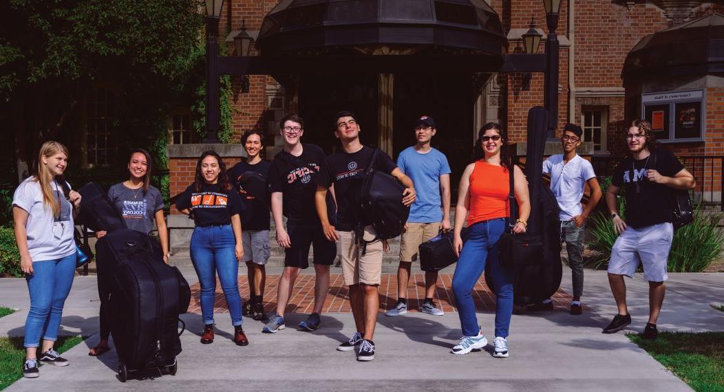 music students standing in front of Faye Spanos Concert hall