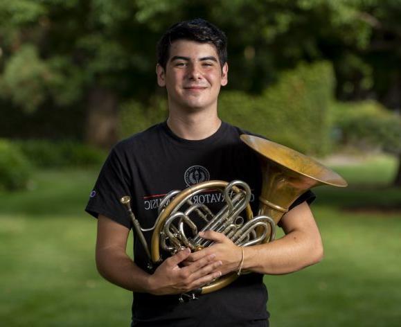 student holding French Horn